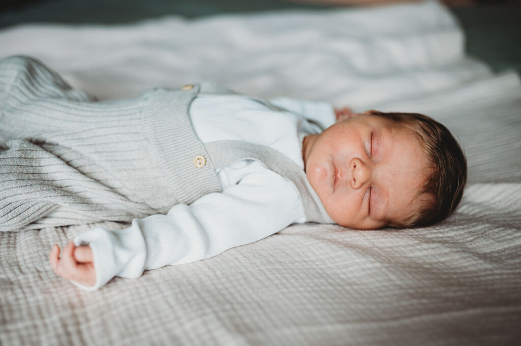 schlafendes neugeborenes Kind auf einer cremefarbenen Decke